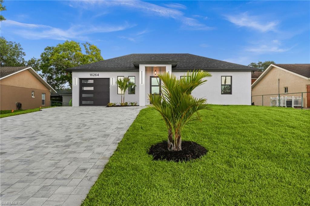 Image 4: Modern single-story residence with a white stucco facade and dark gray roof
