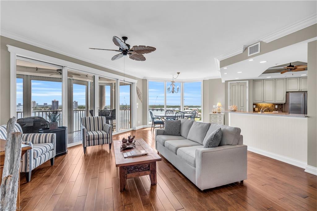 Image 1: Spacious living room with kitchen to the right and views of bay and so much natural light.