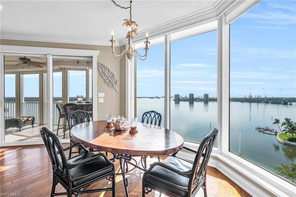 Image 3: Dining space featuring ceiling fan, crown molding, hardwood / wood-style floors, and the mesmerizing Bay view