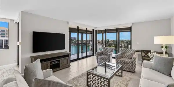 Image 2: Spacious living area featuring large format tile flooring and extensive sliding glass doors