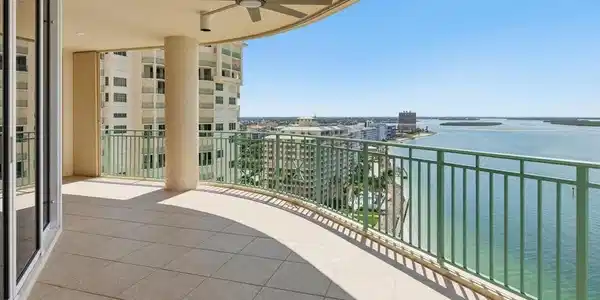 Image 4: Expansive outdoor balcony with tile flooring and a curved green railing