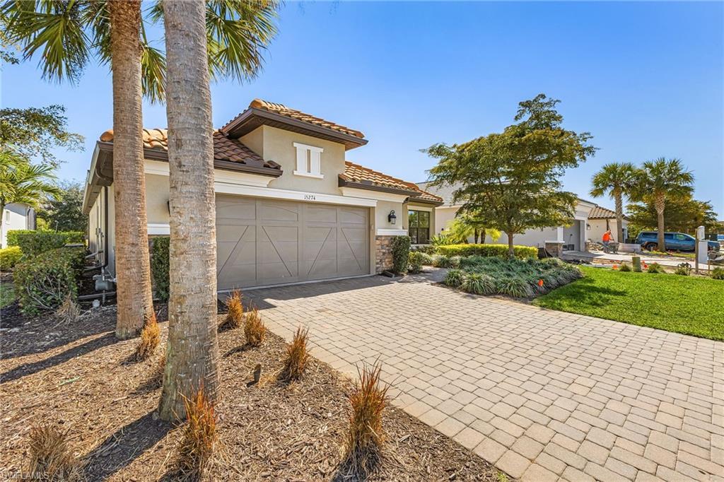 Image 4: Mediterranean / spanish house featuring driveway, stucco siding, a tiled roof, stone siding, and a garage