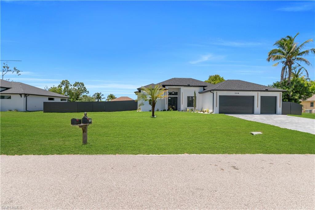 Image 3: Modern single-story residence featuring a white stucco exterior with dark trim accents, a black shingle roof, and an expansive green lawn