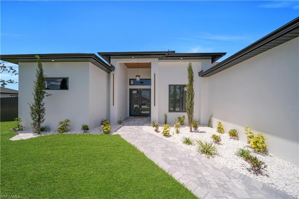 Image 4: Modern architectural exterior featuring white stucco finishes and a dark soffit