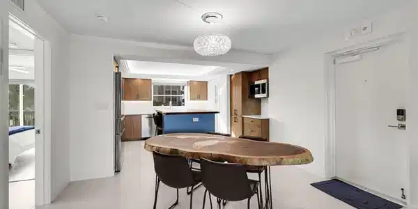 Image 3: Open concept living area featuring light-toned tile flooring and white walls