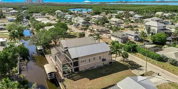 Image 2: Aerial view of residential area with a large body of water