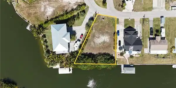 Image 3: Aerial overview of property's location with a large body of water and property parcel outlined