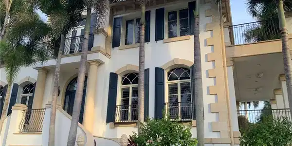 Image 2: Stately exterior with decorative stone accents, arched windows, and dark louvered shutters