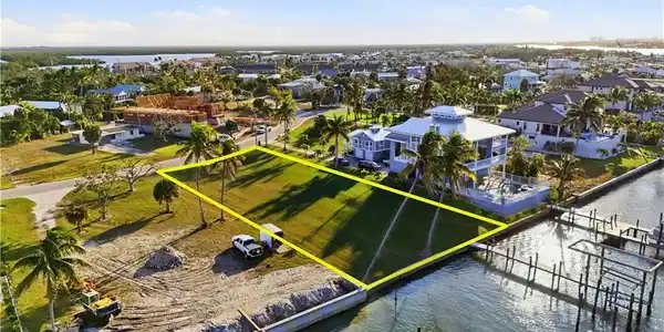 Image 4: Aerial view of residential area with property boundaries highlighted and a large body of waterchange color of water into natural dark blue canal water