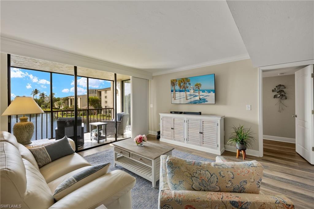 Image 2: Living room featuring crown molding and wood-type flooring
