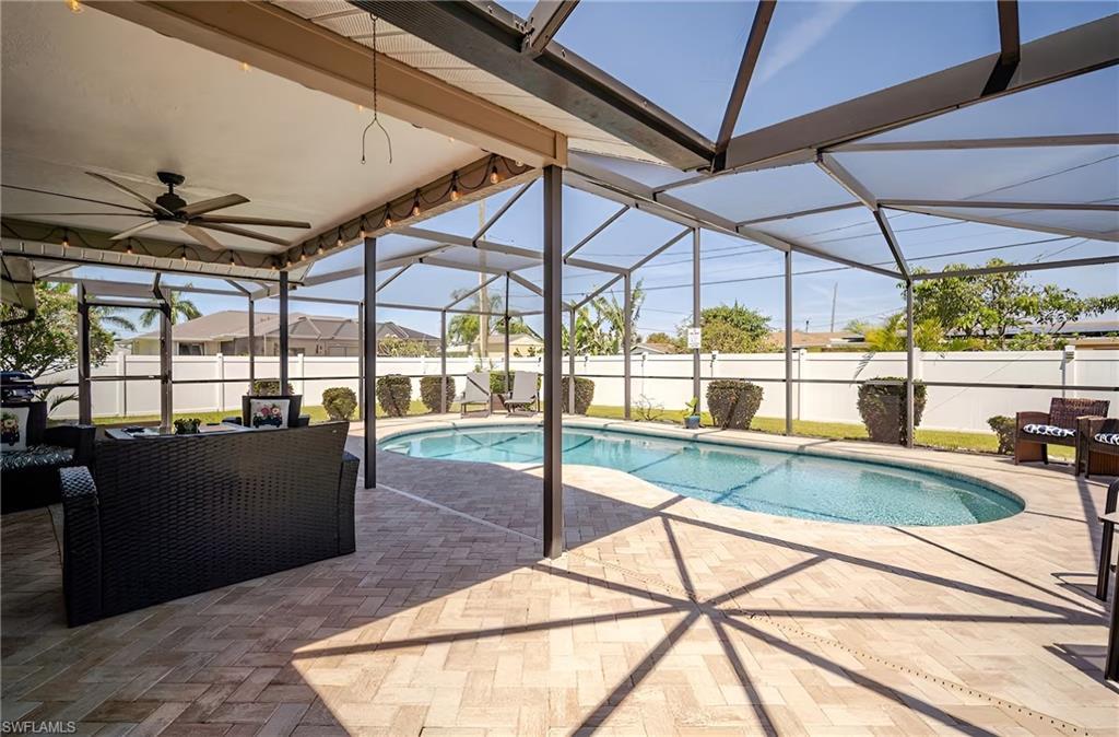 Image 3: View of pool featuring glass enclosure, a sunroom, a patio, and ceiling fan