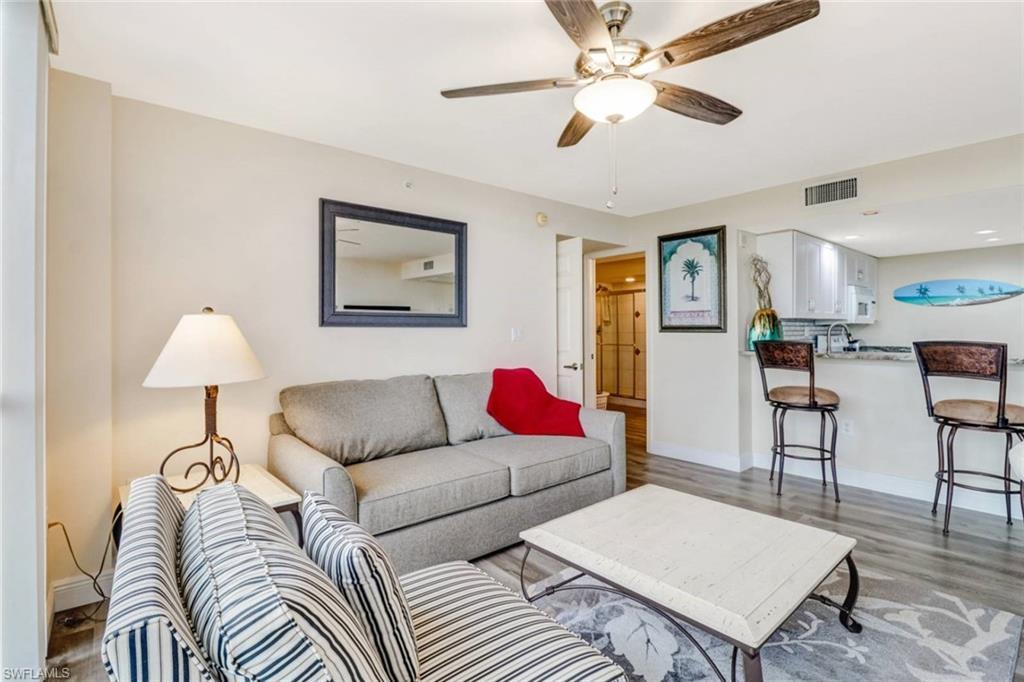 Image 3: Living area with light wood finished floors and ceiling fan