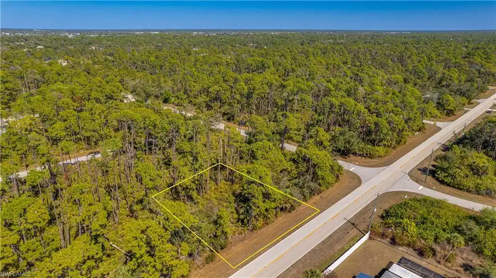 Image 1: Aerial overview of property's location featuring a forest and property boundaries highlighted