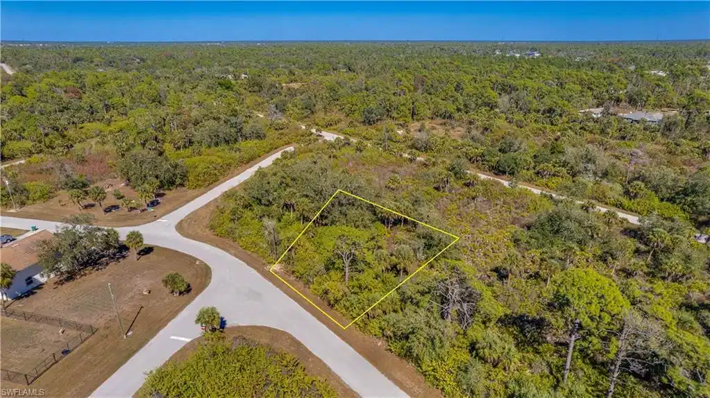 Image 1: View of property location featuring a heavily wooded area and property parcel outlined