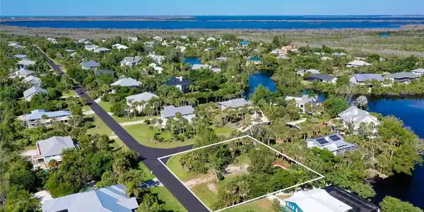 Image 3: Aerial view of residential area featuring a nearby body of water and property boundaries highlighted
