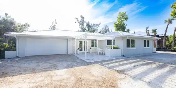 Image 2: Ranch-style home with a pergola, a patio area, dirt driveway, and a garage
