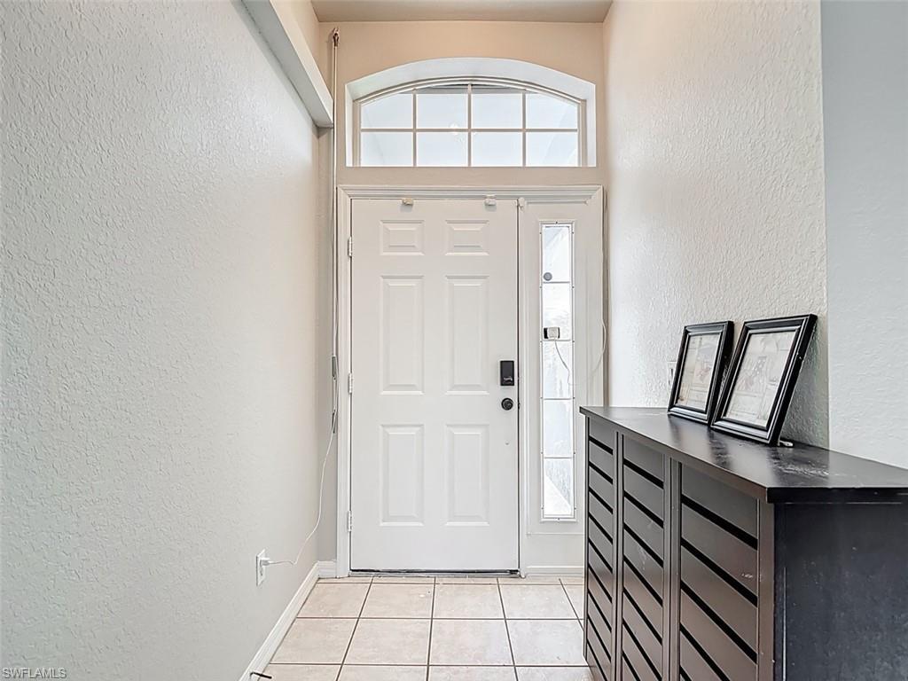 Image 4: Foyer featuring a textured wall and light tile patterned flooring