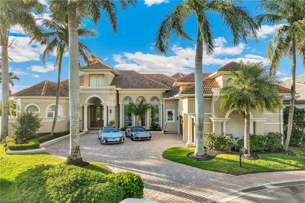 Image 2: View of front of home with curved driveway, a tiled roof, and stucco siding