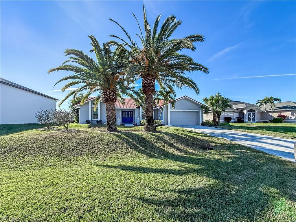Image 2: View of front of house featuring concrete driveway, a front yard, stucco siding, and a garage