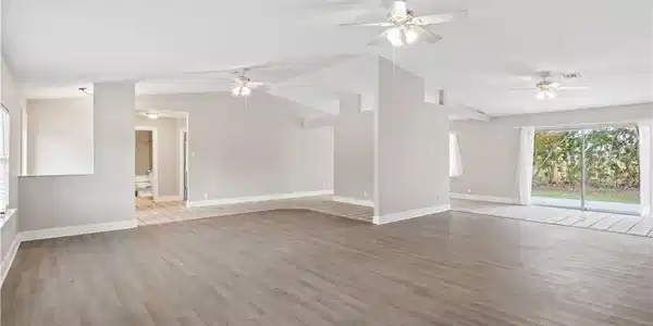 Image 4: Bright and open living space featuring soaring cathedral ceilings, abundant natural light, and a seamless flow perfect for everyday living and entertaining.