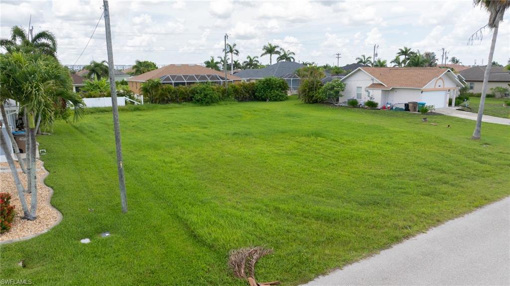 Image 2: View of grassy yard featuring driveway and a residential view