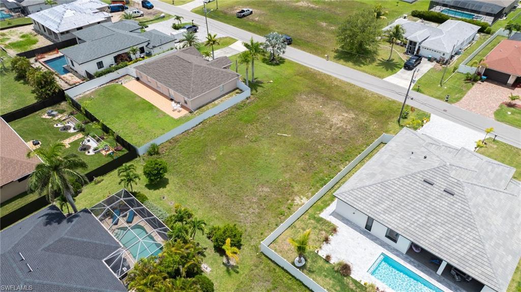 Image 4: Aerial perspective of suburban area featuring a pool area