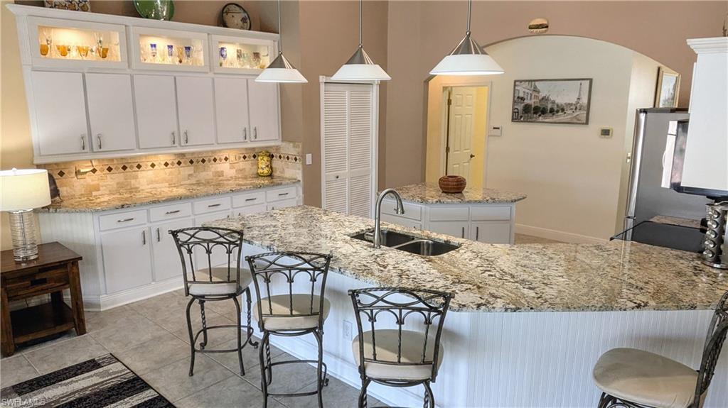 Image 2: The 42 inch Lighted Kitchen Cabinets & Under Cabinet Lighting Showcases the magnificent Granite Counters and Stone Backsplash