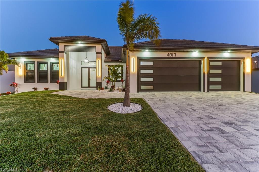 Image 2: featuring a yard, paver driveway,d 3 car garage