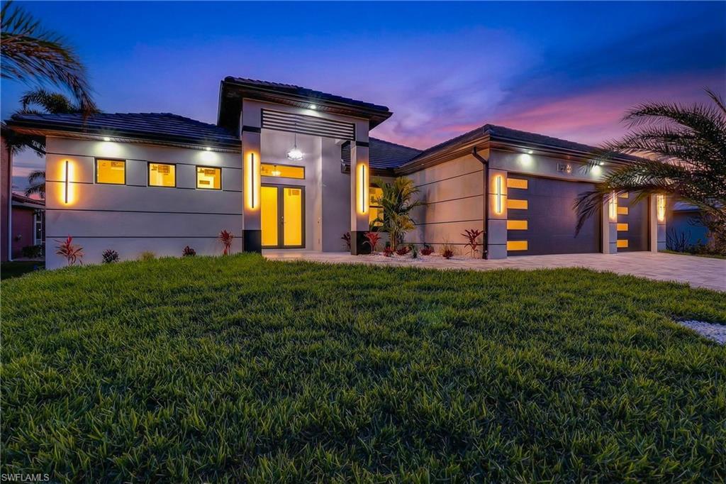Image 1: Modern home with a garage, driveway, a front yard, and stucco Block Structure