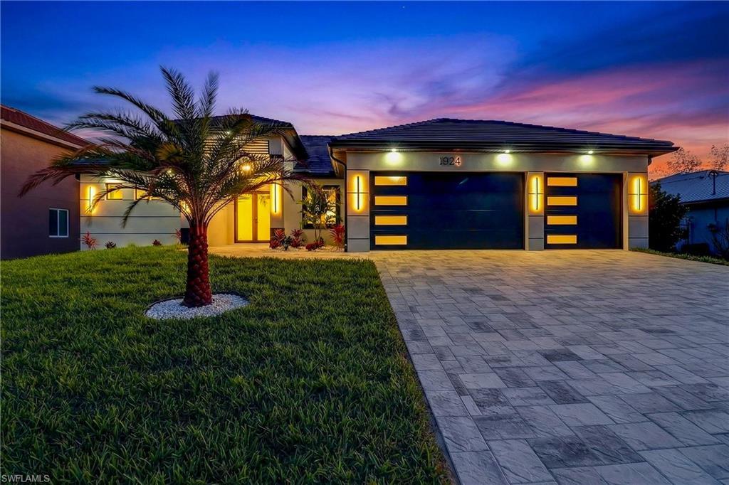 Image 2: View of front of property with a front lawn, driveway, an attached garage, and stucco Block Structure.
