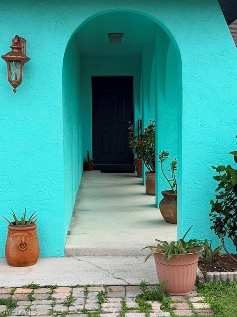 Image 1: View of exterior entry featuring stucco siding