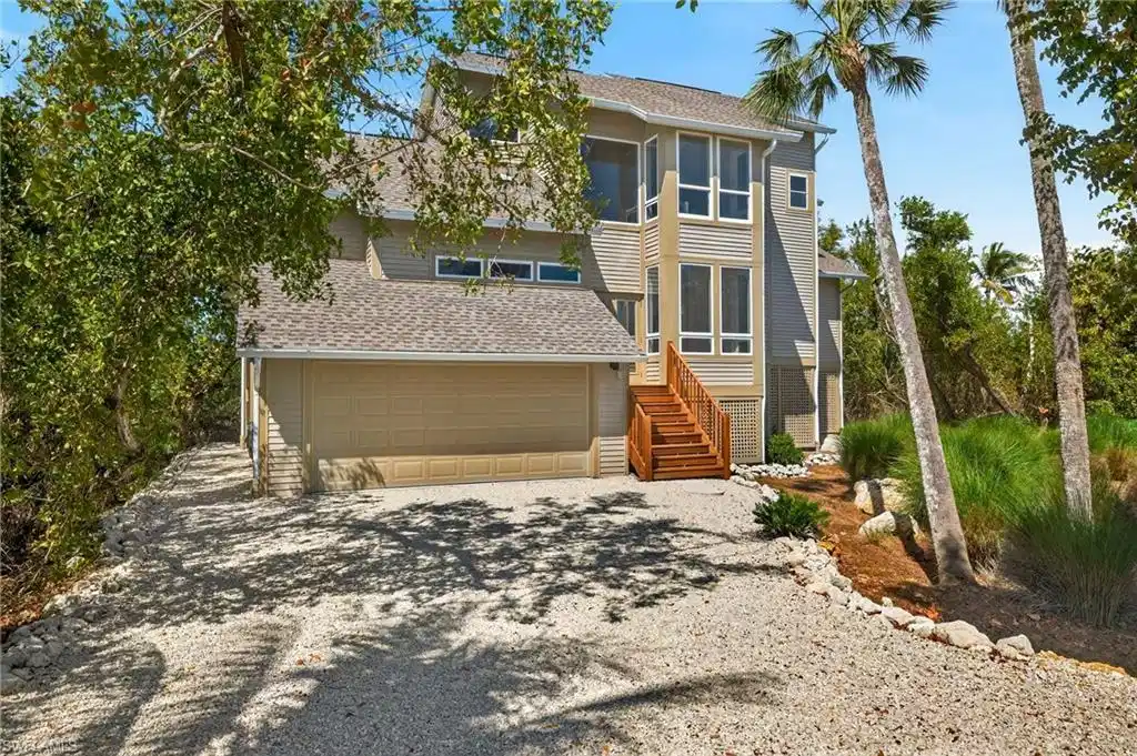 Image 1: View of front of home with driveway, roof with shingles, and an attached garage