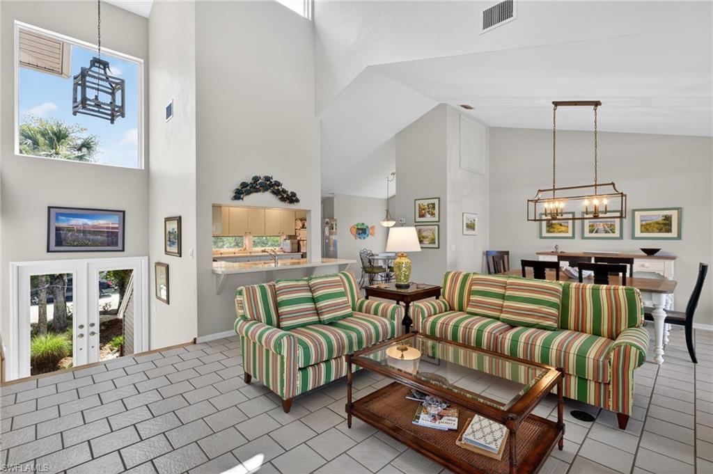 Image 4: Living area featuring a chandelier, a high ceiling, and french doors