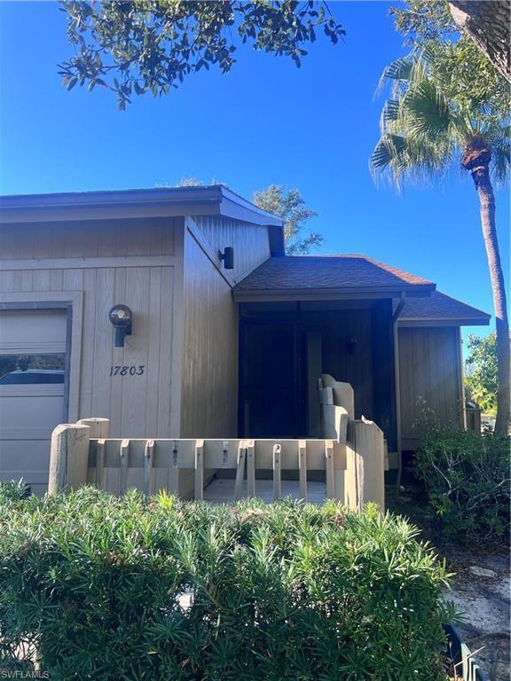 Image 2: Doorway to property featuring a garage and roof with shingles