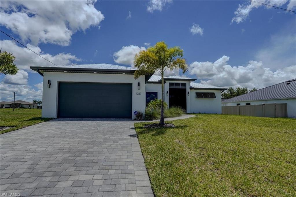Image 4: View of front facade featuring a garage and a front yard