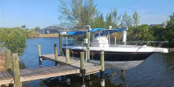 Image 2: Private boat dock featuring wood decking and a covered boat lift