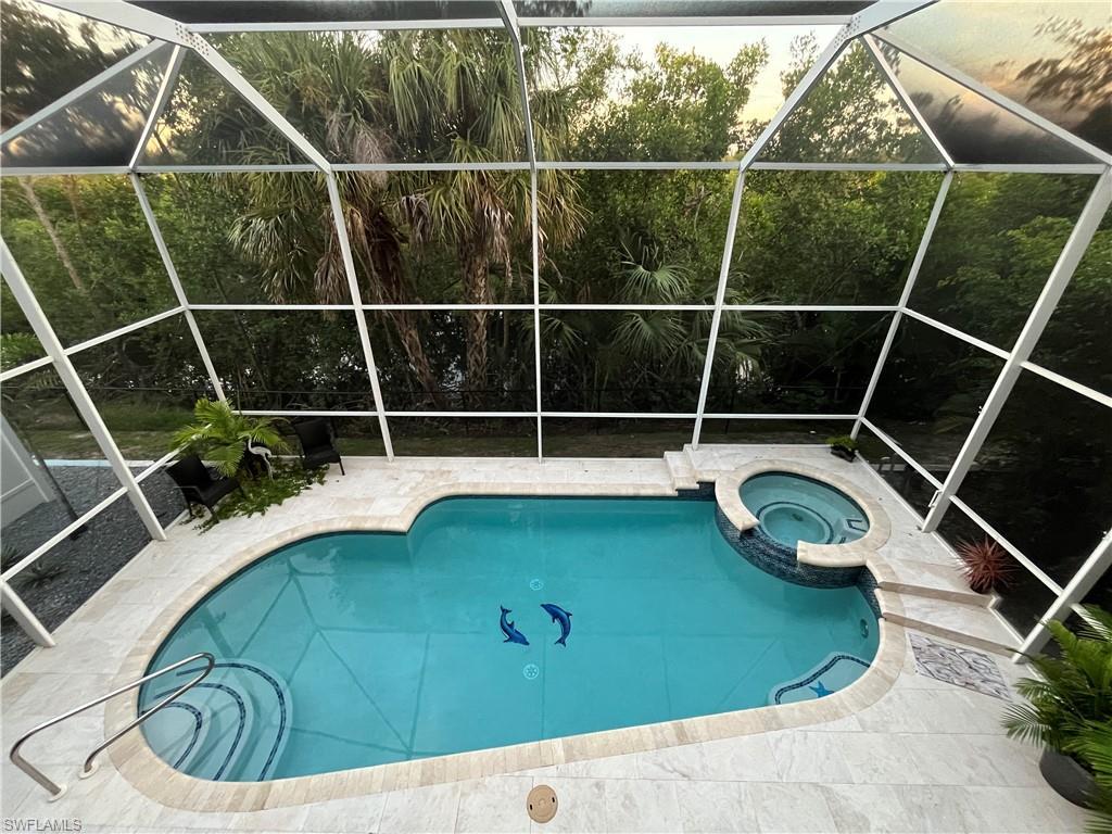 Image 2: Large 2 story screen enclosure with a heated pool and spa.
