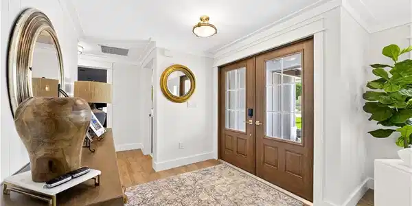 Image 2: Entryway featuring double wood-paneled doors with glass inserts, wood-finish flooring, and crown molding