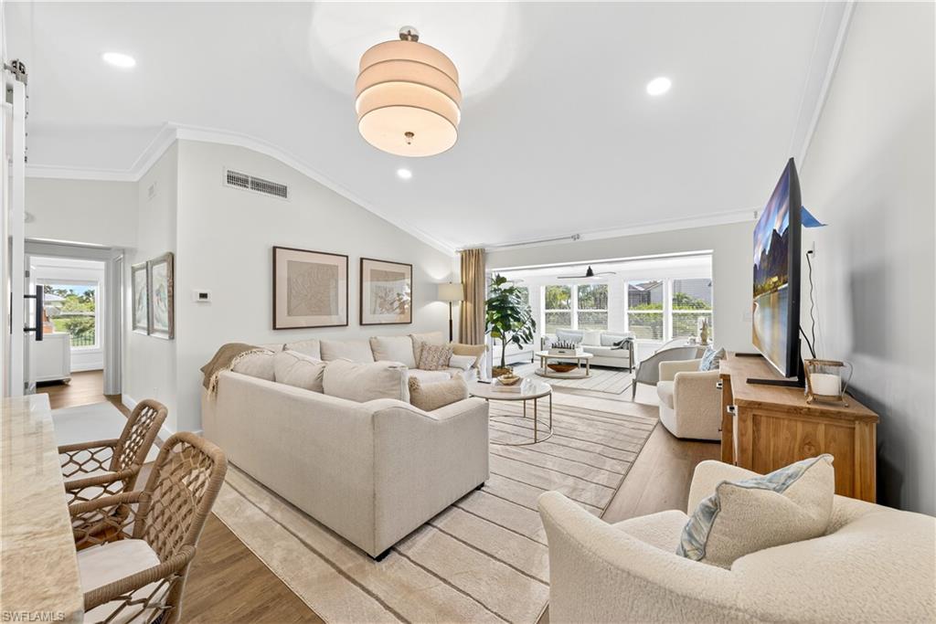 Image 3: Spacious living area featuring high vaulted ceilings, recessed lighting, and wood-finish flooring