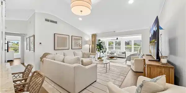 Image 3: Spacious living area featuring high vaulted ceilings, recessed lighting, and wood-finish flooring