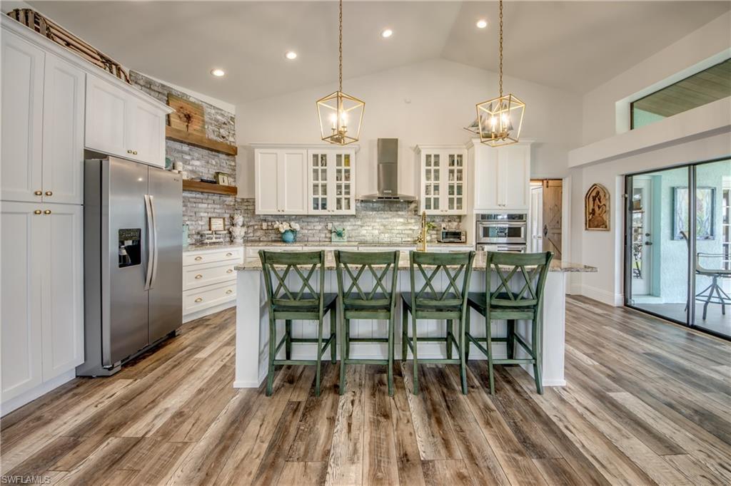 Image 3: Kitchen with large granite island, apron sink and stainless appliances