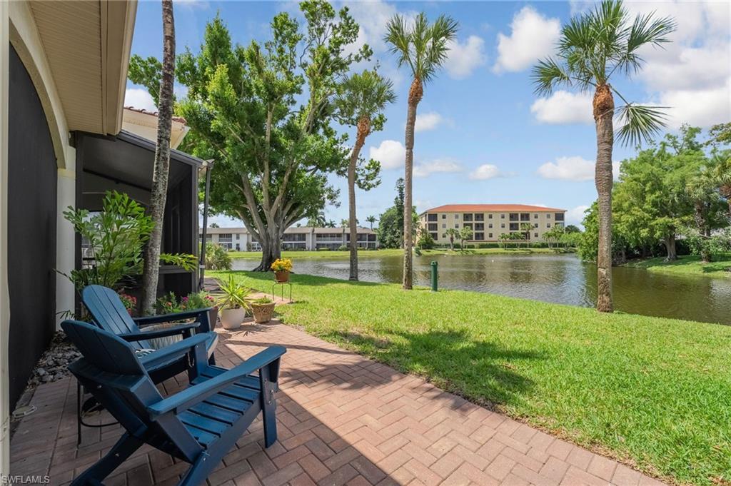 Image 3: An inviting outdoor seating area captures even more expansive lake views, set upon a beautifully pavered deck and enhanced with a guttered system for added comfort and functionality.