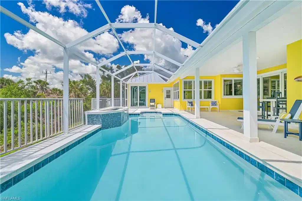 Image 1: Screened outdoor pool with integrated spa and surrounding deck
