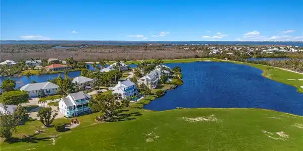 Image 2: Aerial view of residential area featuring a large body of water and a local golf course