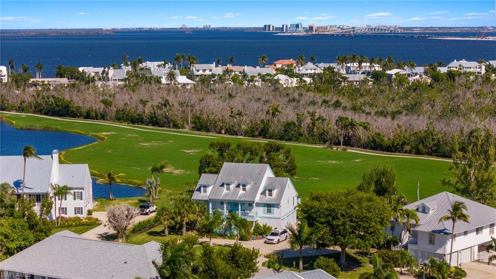 Image 4: Aerial perspective of suburban area featuring a nearby body of water and a golf club