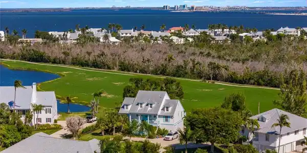 Image 4: Aerial perspective of suburban area featuring a nearby body of water and a golf club