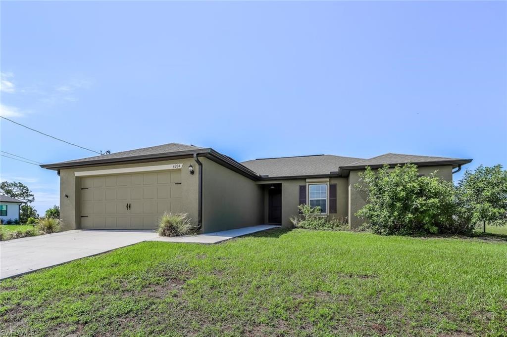 Image 1: Single-story residence featuring a two-car garage with decorative hardware, a concrete driveway, and a front entry with a covered porch