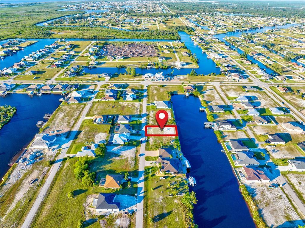 Image 1: Waterfront parcel featuring direct canal access, a surrounding residential area, and a clear, buildable lot