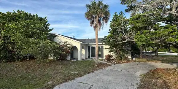 Image 2: Single-story residence featuring a stucco exterior and dark shutters