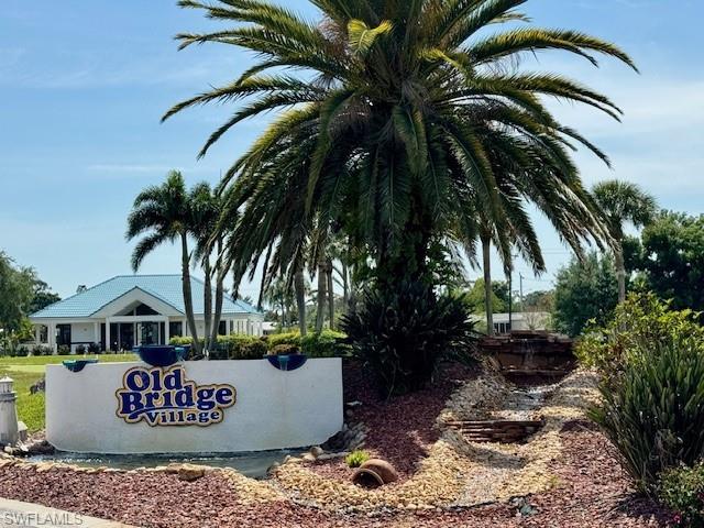 Image 4: Community entrance featuring a prominent sign, tropical landscaping with palm trees, and a multi-tiered rock waterfall